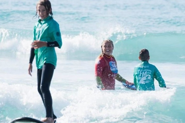 a group of people standing next to a body of water