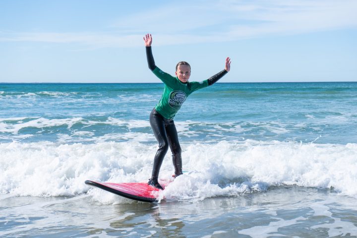 a girl riding a wave on a surfboard in the ocean