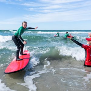 a girl riding a wave on a surfboard in the water