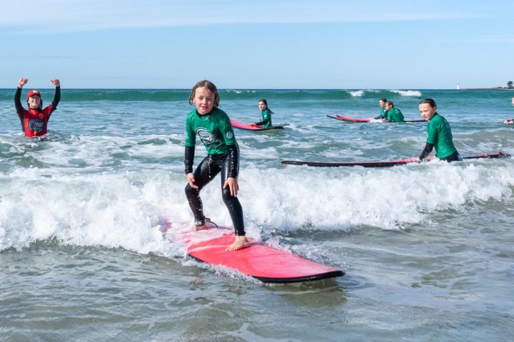 a girl riding a wave on a surfboard in the ocean