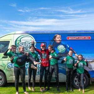 a group of people standing in front of a car posing for the camera